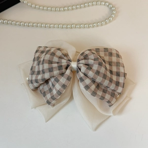 Détail de la pince à cheveux nœud à carreaux avec organza et accents de perles fines