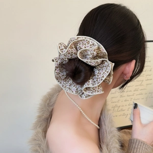 Chouchou fleuri surdimensionné avec volants superposés pour coiffure élégante en queue