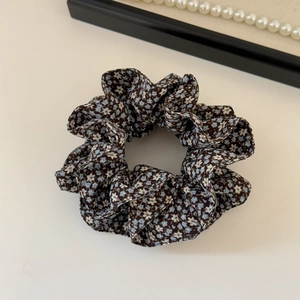 Detailed texture of blue floral scrunchie with layered fabric and elegant folds