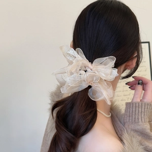 Chouchou nœud en organza champagne scintillant sur une coiffure élégante et chic