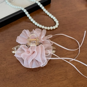 Detail der Haarklammer aus rosa Spitze mit Falten und eleganten Bändern auf Holz