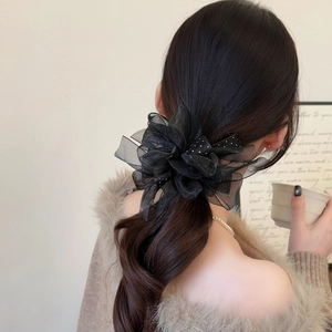 Chouchou élégant en tulle noir avec fleurs et paillettes brillantes sur modèle