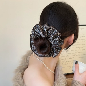 Chouchou géant à motif floral et bords ondulés sur une coiffure en queue de cheval