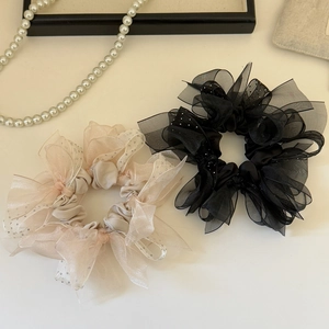 Vue détaillée de chouchous en organza noir et beige avec des accents de strass brillants