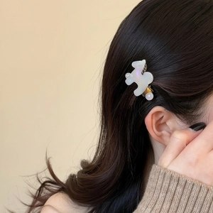 Pince à cheveux blanche irisée en forme de puzzle avec strass sur les cheveux