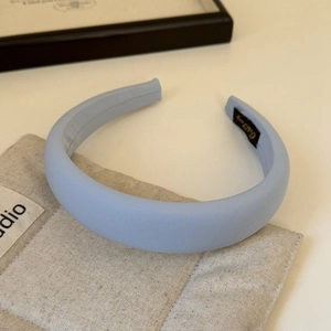Macro detail of the light blue striped fabric headband with a non-slip black inner lining