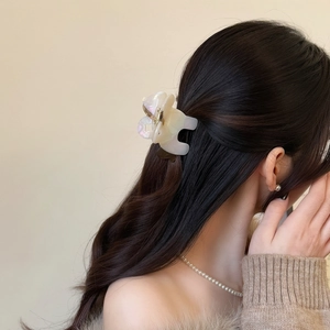 Pince à cheveux élégante en acétate ivoire sur cheveux bruns pour un style minimaliste