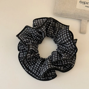 Gros plan détaillé d'un chouchou à carreaux noir et blanc avec texture en tissu doux