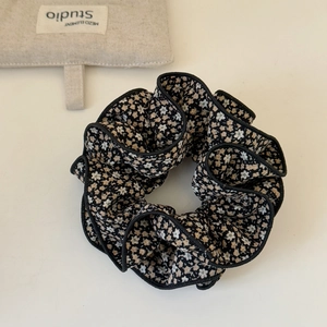 Gros plan détaillé du chouchou floral avec bordure noire et motif de fleurs élégant