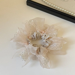 Détail d'un chouchou en organza champagne avec paillettes argentées et volants amples