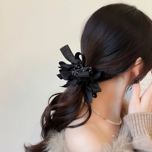 Elegante elastico per capelli a pois neri con fiocco indossato su una coda di cavallo