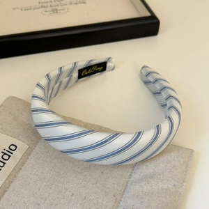 Detail of blue striped padded sponge headband with brand label on a canvas bag