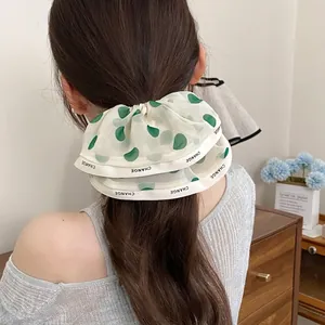 Elegant beige chiffon oversized scrunchie with green polka dots and CHANGE letter ribbon