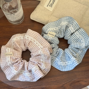 Lot de chouchous à carreaux roses et bleus avec bordure en dentelle sur un bureau en bois