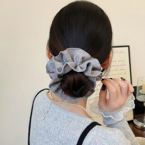 Chouchou élégant à carreaux gris-violet pour femme porté sur un chignon flou