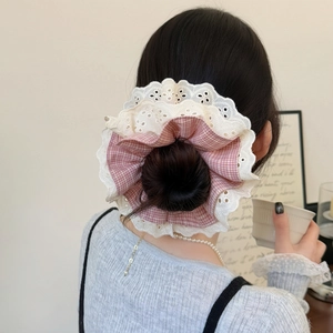 Pink checkered scrunchie with lace trim shown on a model's elegant ponytail hairstyle