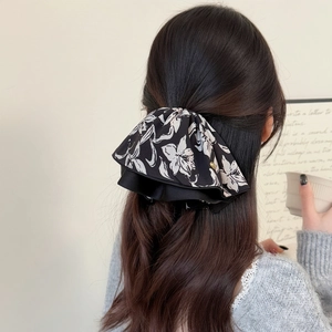 Chouchou élégant en mousseline à imprimé floral noir et blanc dans une coiffure chic