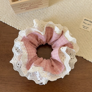Close-up of pink plaid scrunchie with layered white lace embroidery and soft fabric texture