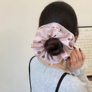 Chic pink oversized hair scrunchie with coffee polka dots on a stylish high bun
