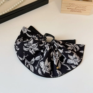 Détail de la pince à cheveux en satin élégante à motif floral noir et blanc