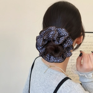 Floral print oversized scrunchie with blue flower pattern on dark fabric for women