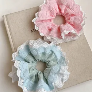 Elastici per capelli a scacchi rosa e blu con bordo in pizzo su un libro