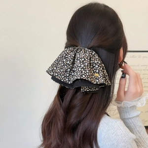 Pince à cheveux fleurie noire avec design double couche et petit accent en métal doré