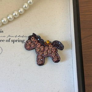 Dettaglio del fermaglio per capelli a forma di pony con strass colorati su bianco
