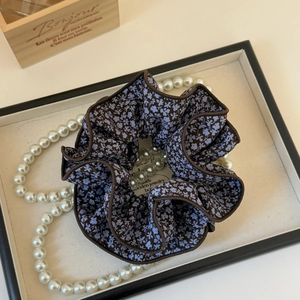Detail of floral scrunchie with intricate brown edging and blue flower pattern