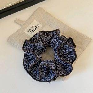 Floral fabric scrunchie in deep blue and brown tones with elegant ruffled layers