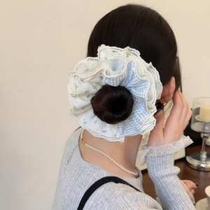 Chic multi-layered plaid and lace scrunchie shown on a bun for a voluminous hairstyling look