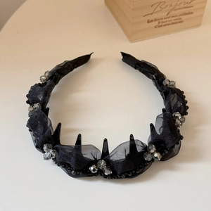 Detailed shot of beaded black mesh headband with pleated fabric and glossy crystals