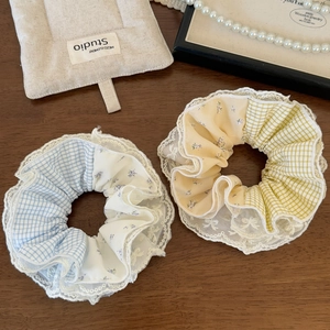 Detailed close-up of sweet lace and plaid scrunchies set on elegant wooden background
