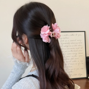 Dettaglio di un fermaglio per capelli a fiori rosa in tessuto per un look romantico