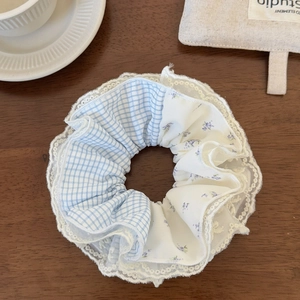 Detail of light blue plaid and lilac floral scrunchie with delicate white lace trim edge