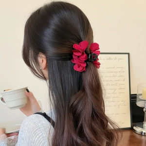 Elegante pinza per capelli con fiore in tessuto rosso mostrata in un contesto di stile