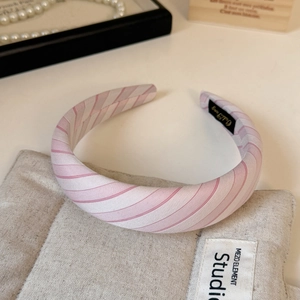 Detailed close-up of a thick padded sponge headband with pink and cream stripes