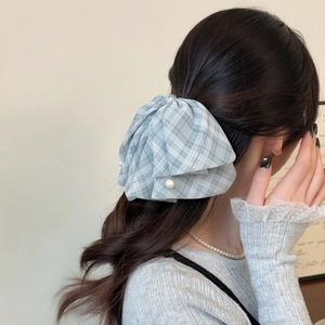 Barrette à nœud papillon à carreaux bleus avec perle sur modèle pour un style élégant