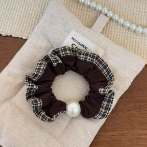 Detail showing high-elastic dark brown plaid scrunchie with large white pearl ornament