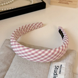 Close-up of pink gingham sponge headband with cotton fabric texture and soft padding