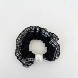 Plaid ruffle scrunchie with large pearl accent for ponytail styling in black and white