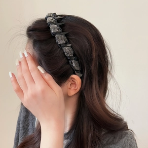 Elegant black padded headband with sparkling crystals worn by a model in a side view profile