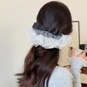 Barrette nœud élégante motif pied-de-poule et dentelle portée à l'arrière de la tête