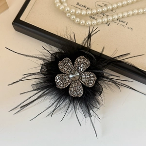 Elegant black feather hair claw clip with floral rhinestone details and a vintage look