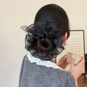 Chouchou élégant en organza noir avec paillettes argentées porté sur un chignon