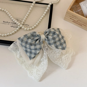 Detail of blue plaid fabric and white lace hair claw clip with pearl embellishments