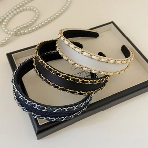 Elegant chain-wrapped headbands in satin and denim fabric displayed on a jewelry tray