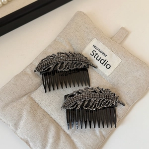 Close-up of leaf hair combs with sparkling rhinestones and black alloy base