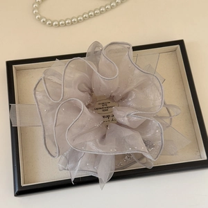 Détail du chouchou en organza lilas orné de paillettes argentées et de plis élégants