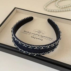 Close-up of denim fabric headband with silver chain trim and soft velvet lining
